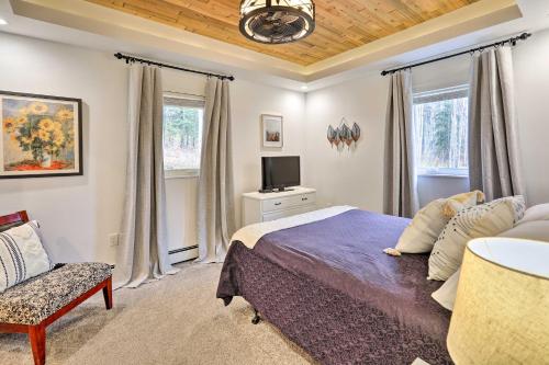 een slaapkamer met een bed, een tv en een stoel bij Convenient Fairbanks Guest Suite with Grill! in Fairbanks