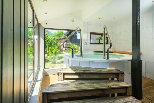 a bathroom with a tub and a sink with mirrors at Chalets de la Wormsa in Metzeral