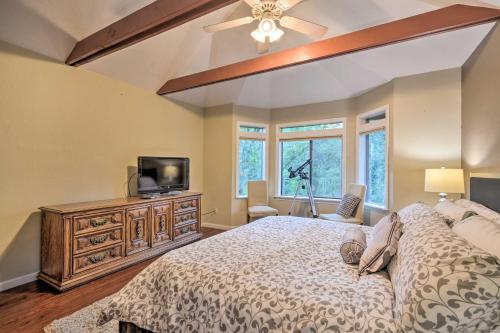 a bedroom with a bed and a tv and windows at Deck + Grill: Mtn Haven in Stanislaus Nat'l Forest in Arnold