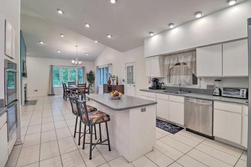 Una cocina grande con gabinetes blancos y taburetes de bar. en Private Yard Pet-Friendly Home in Dover, en Dover