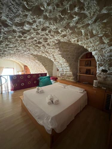 a bedroom with a bed in a stone wall at Admirari in Tropea