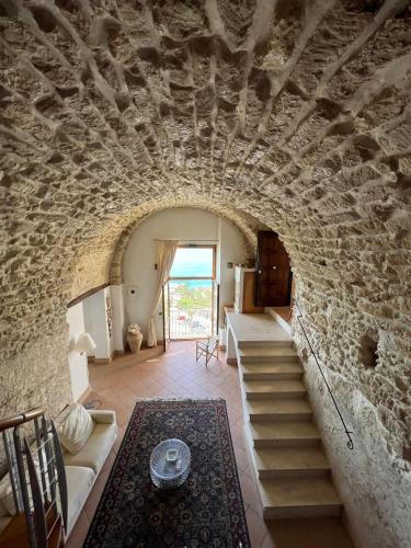 a living room with a stone wall and stairs at Admirari in Tropea