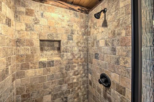 a bathroom with a shower with a stone wall at NEW The Deer Cabin Peaceful Refuge in East Texas in Ben Wheeler