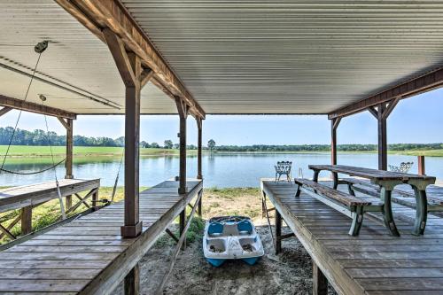 a dock with a boat sitting on the water at NEW The Deer Cabin Peaceful Refuge in East Texas in Ben Wheeler