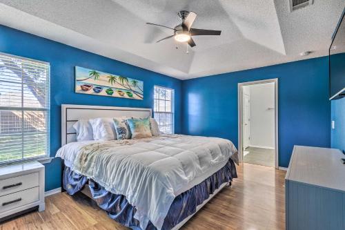 um quarto azul com uma cama e uma ventoinha de tecto em Bright Pensacola Home with Yard about 6 Mi to Beach em Pensacola