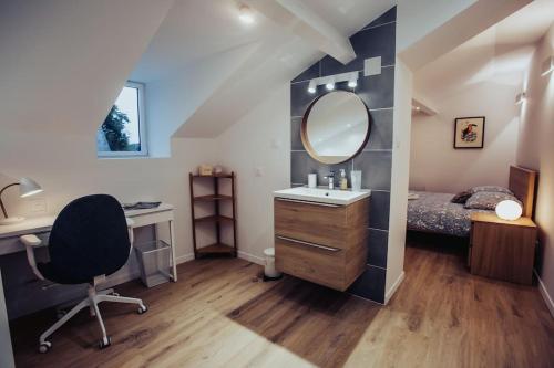 ein Schlafzimmer mit einem Waschbecken, einem Spiegel und einem Bett in der Unterkunft Appartement de charme, Angers Belle-Beille in Angers