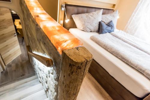 a bedroom with a bed with a wooden rail at Himmelsbögen und Apartments mit Seeblick und Alleinlage in Weissensee