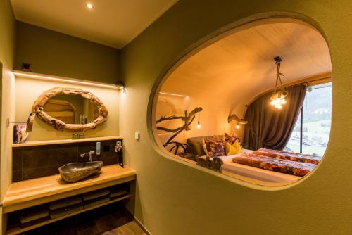 a bathroom with a large mirror and a bed at Himmelsbögen und Apartments mit Seeblick und Alleinlage in Weissensee