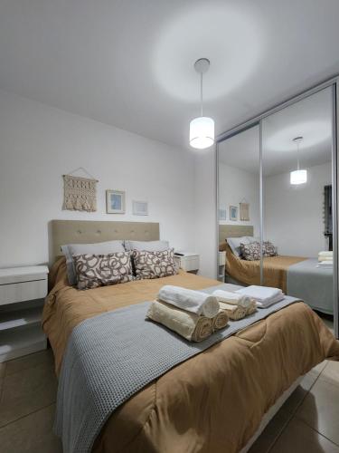 1 dormitorio con 1 cama grande y toallas. en Hermoso y luminoso dpto en plaza mitre en Mar del Plata