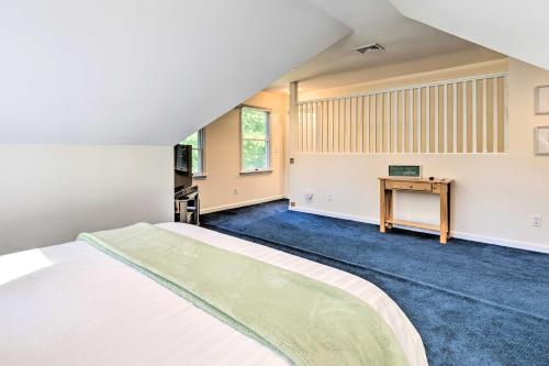 a bedroom with a large bed and a desk at Classy Getaway with Deck and Yard Less Than 1 Mi to Beach in Riverhead