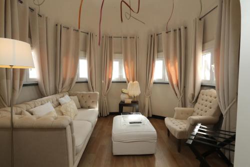 a living room with a white couch and two chairs at Hotel Inglaterra - Charme & Boutique in Estoril