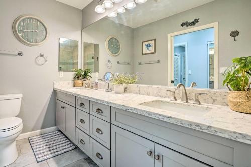 a bathroom with a sink and a toilet and a mirror at Coastal Ko Olina Townhome - Walk to Beaches! in Kapolei
