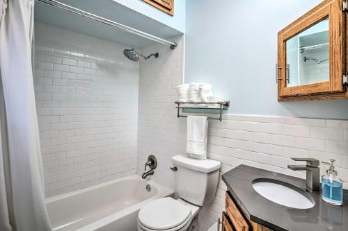 een witte badkamer met een toilet en een wastafel bij Minneapolis Townhome with Loft Less Than 3 Mi to Dtwn! in Minneapolis