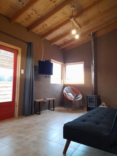 a bedroom with a bed and a tv on the wall at Eco Parcela La Chacra in Catapilco