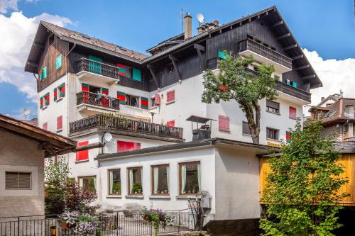 - un bâtiment blanc avec un balcon et un arbre dans l'établissement Résidence Le Panorama - Megève, à Megève