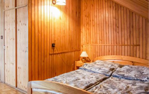 sypialnia z łóżkiem w drewnianej ścianie w obiekcie Ranczo w mieście Mogilany