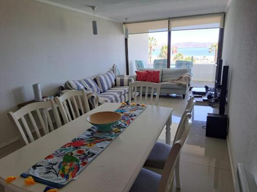 ein Wohnzimmer mit einem Tisch und Stühlen in der Unterkunft Condominio Jardín del Mar in Coquimbo