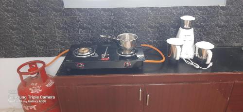 a small stove on top of a counter in a kitchen at Madura Homestay - Gorgeous Home with 2BHK 5 minutes from NH44 in Madurai