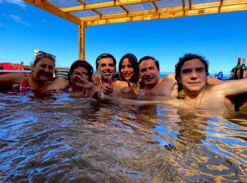 um grupo de pessoas nadando na água em El Reflejo Lodge Spa - Queilen - Chiloé em Queilén