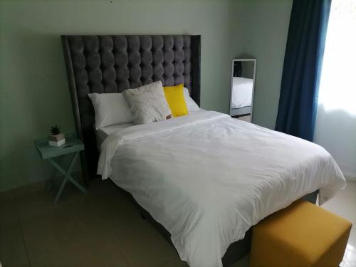 a bedroom with a large bed with a large headboard at Queens And Kings Lodge in Durban