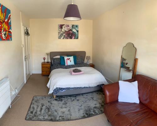 a bedroom with a bed and a couch at The Gatehouse in Folkestone