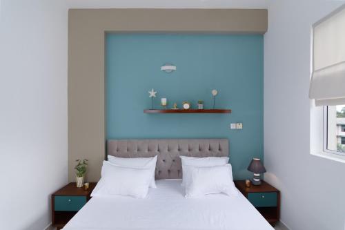 a bedroom with a white bed with a blue wall at The Luxury Nest in Maharagama