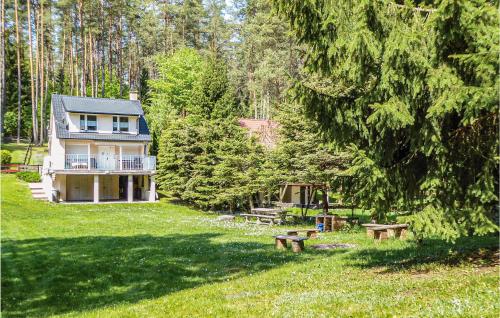 a house in the middle of a yard with a picnic table at One-Bedroom Holiday Home In Biskupiec in Biskupiec
