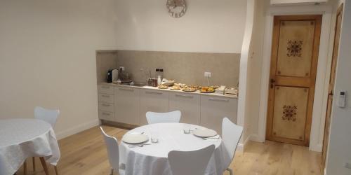 a kitchen with a white table and white chairs at B&B Dimora Damiani in Montefiore dellʼAso