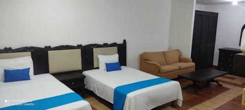 a hotel room with two beds and a chair at HOTEL BLUE in Puerto Vallarta