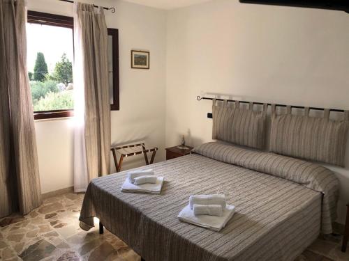 a bedroom with a bed with two towels on it at U Puzzu Ranne in Buseto Palizzolo