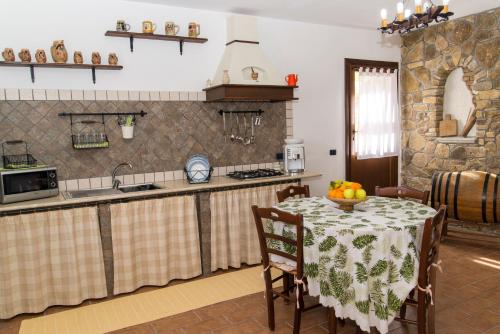a kitchen with a table with a bowl of fruit on it at U Puzzu Ranne in Buseto Palizzolo