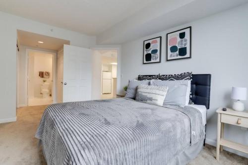a white bedroom with a large bed and a table at Fascinating 1 Bedroom Condo At Ballston With Gym in Arlington
