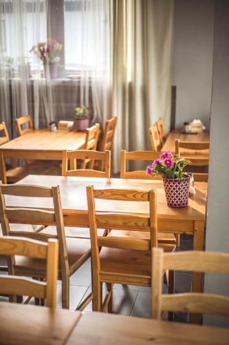 a restaurant with wooden tables and chairs with flowers on them at 4 Couples & 4 Friends Hostel in Krakow