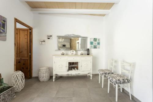 een kamer met een wit dressoir en 2 stoelen bij House Can Diana 454 in Campanet