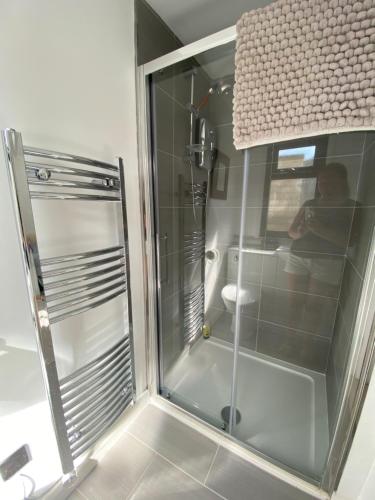 eine Dusche mit Glastür im Bad in der Unterkunft Stonebury Lodge in Coventry