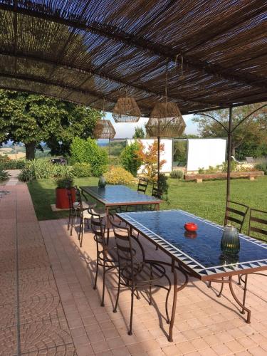 a picnic table with chairs under a pergola at Aux Coteaux d'Aussac in L Honor De Cos