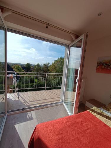 a bedroom with a large glass door to a balcony at Ferienwohnung zum Wohlfühlen in Lengerich