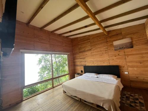 a bedroom with a bed and a large window at Luxury Tiny House - Minca in Minca