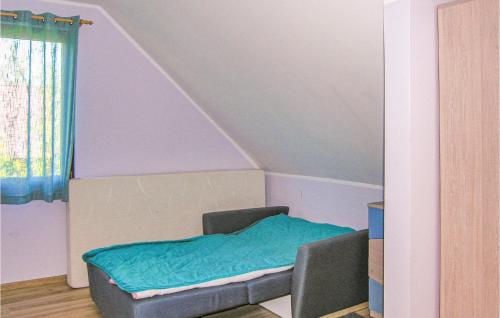 ピシュにあるBeautiful Home In Pisz With 4 Bedrooms, Wifi And Outdoor Swimming Poolの青い毛布付きのベッドが備わる客室です。
