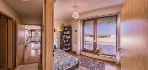1 dormitorio con vistas al océano desde una ventana en Budapest Top Apartment with Private 90 sqm Rooftop, Free Parking and Air Condition, en Budapest