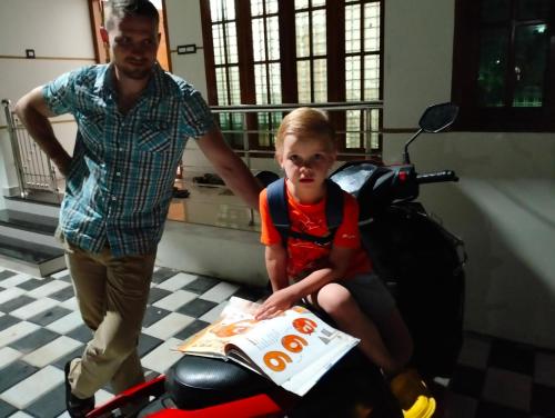 a man standing next to a girl sitting on a scooter at Devi Kripa Residency in Varkala