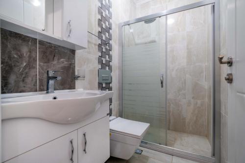 een badkamer met een wastafel, een toilet en een douche bij Kayaköy İncir villa özel yüzme havuzlu in Fethiye