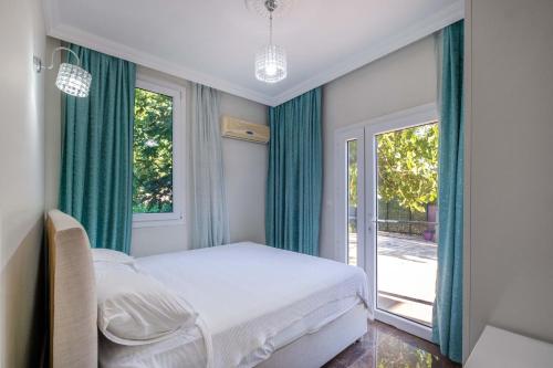 een slaapkamer met een bed en een groot raam bij Kayaköy İncir villa özel yüzme havuzlu in Fethiye