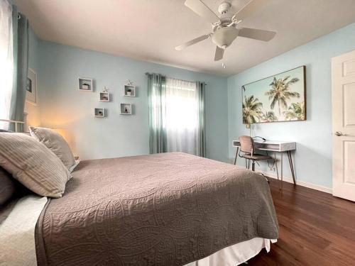 een slaapkamer met een bed en een plafondventilator bij The Brick Beach House in Jacksonville Beach