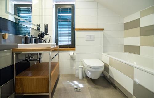 a bathroom with a toilet and a sink and a tub at Gorgeous Apartment In Nidzica With Sauna in Nidzica