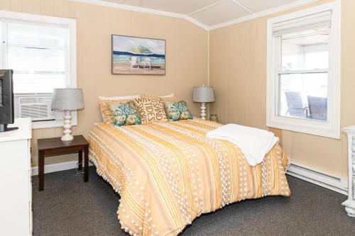 een slaapkamer met een bed, een bureau en 2 ramen bij Warm and Coasty - Top in North Topsail Beach
