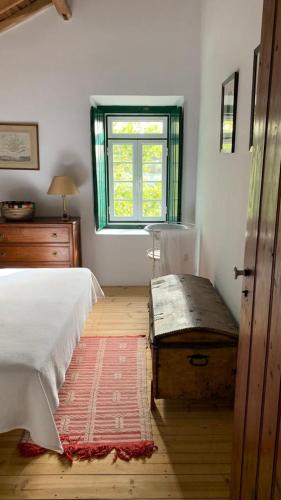 a bedroom with a bed and a table and a window at Quinta de SantAna da Várzea in Abrantes
