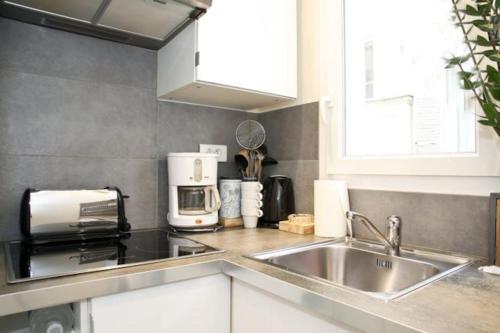 a kitchen with a sink and a microwave at JULES JO in Paris