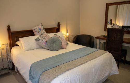 a bedroom with a large white bed with pillows at Mi Vida Guesthouse in Klerksdorp