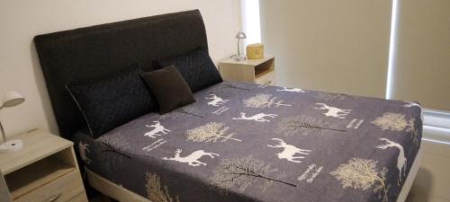 a bedroom with a bed with a blanket with horses on it at Top Department in Buenos Aires